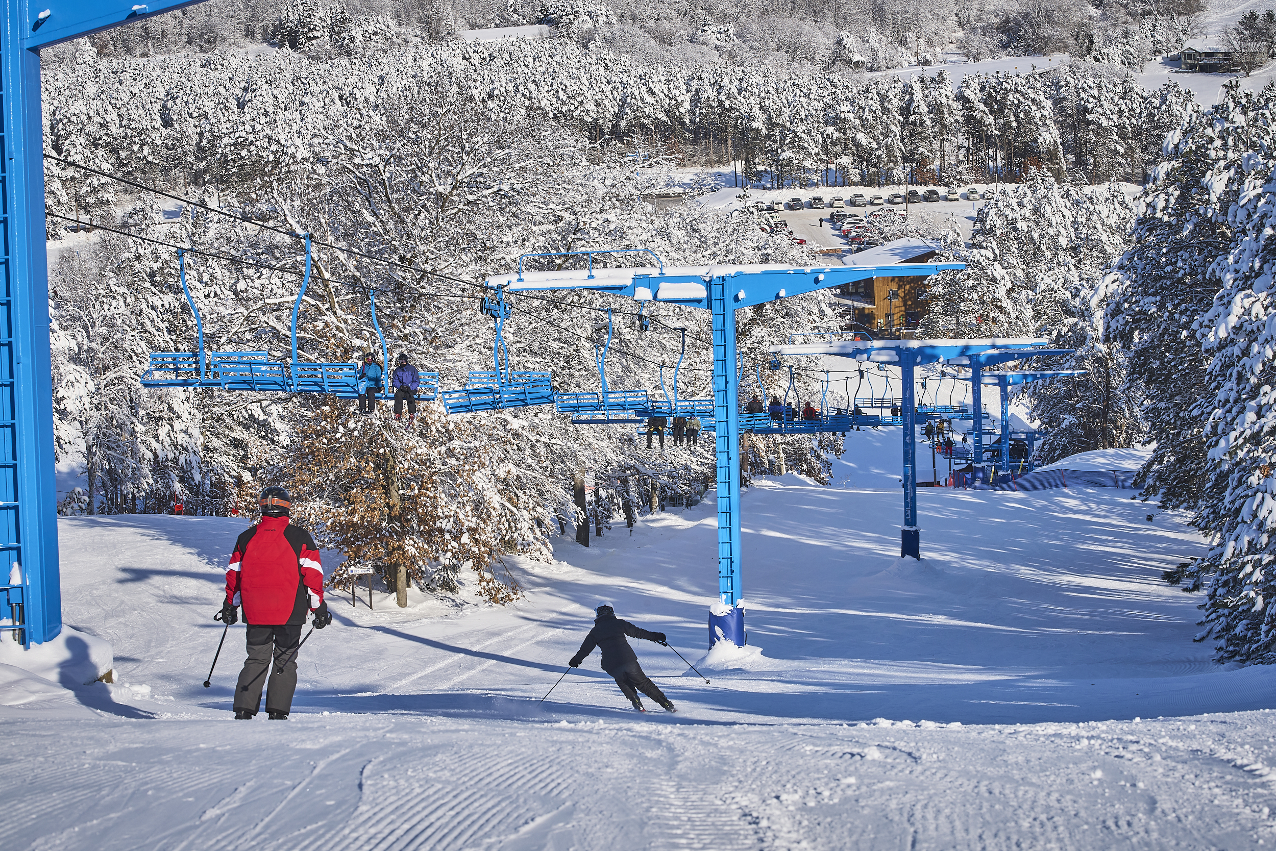 Photo of Trollhaugen hill during winter - with two skiers with a chairlift above them
