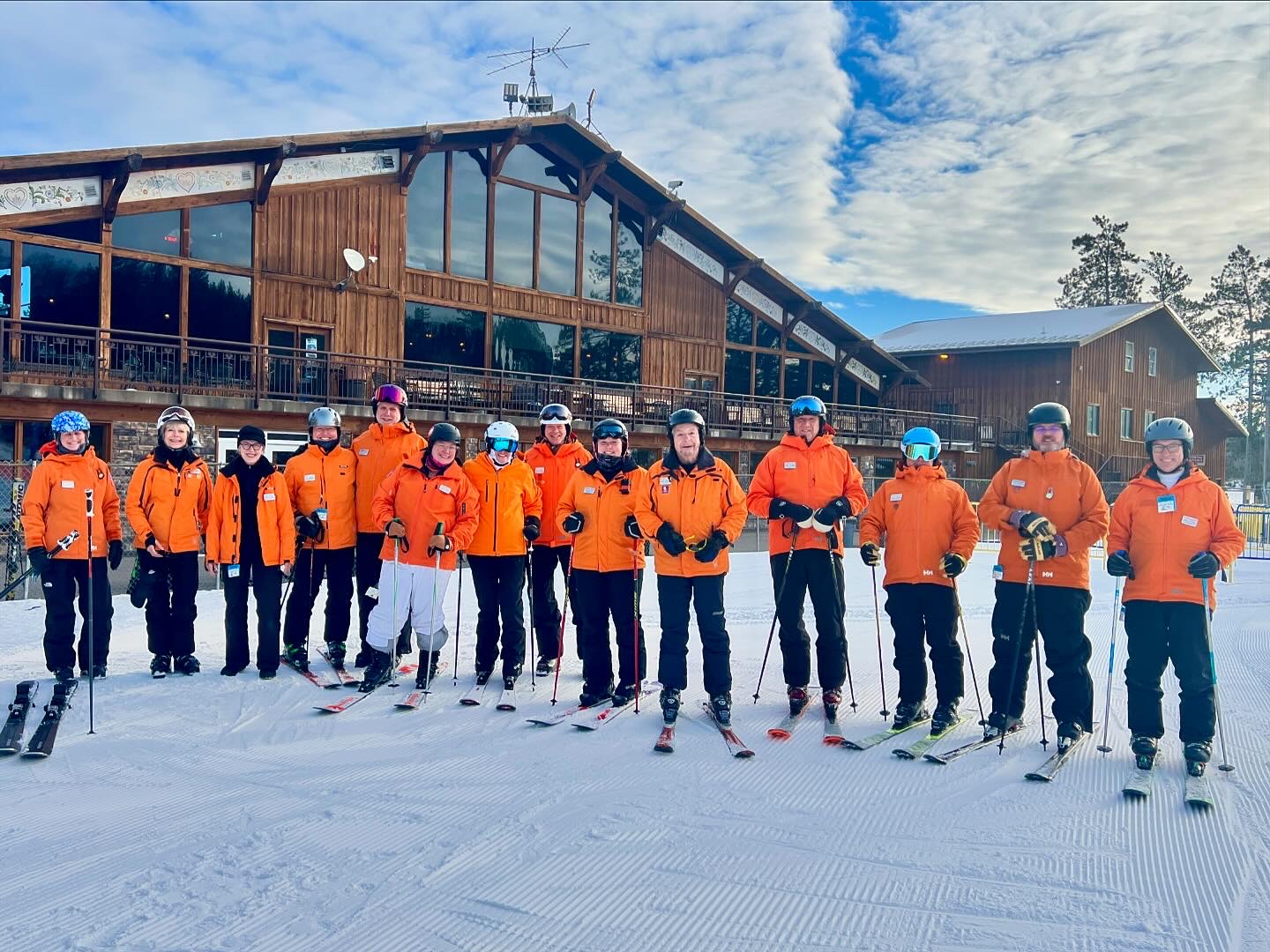 Photo of a group of Trollhaugen ski instructors - with the chalet in the background